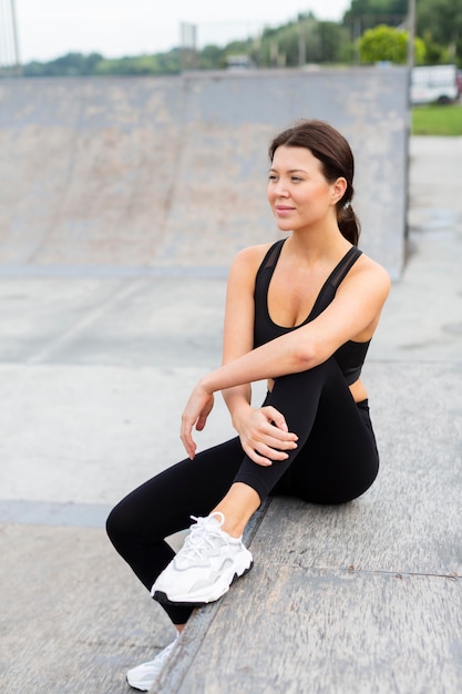 Vista frontal de la mujer en athleisure posando al aire libre