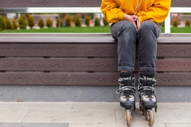 Foto gratuita vista frontal de la mujer en el banco con patines