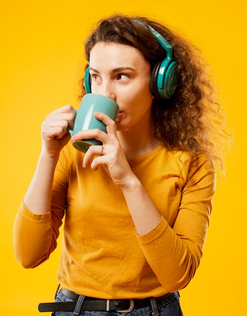 Vista frontal de la mujer bebiendo de la taza verde