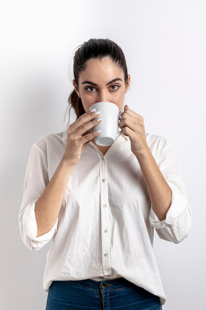 Vista frontal de la mujer bebiendo de la taza