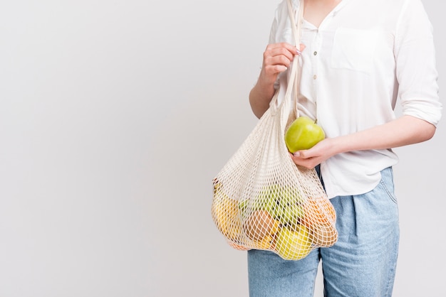 Foto gratuita vista frontal de mujer con bolsa de frutas