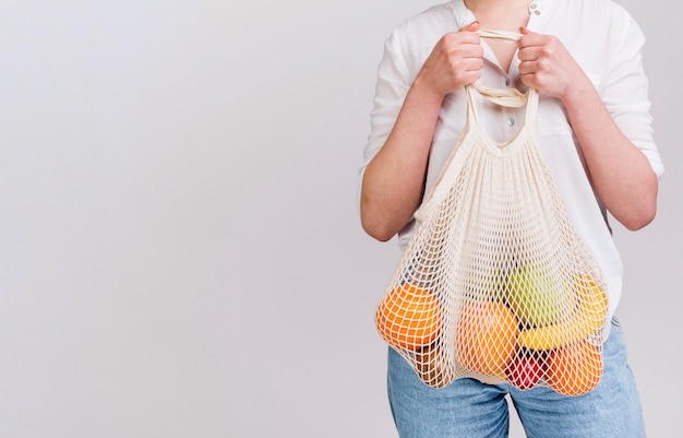 Foto gratuita vista frontal de mujer con bolsa de frutas