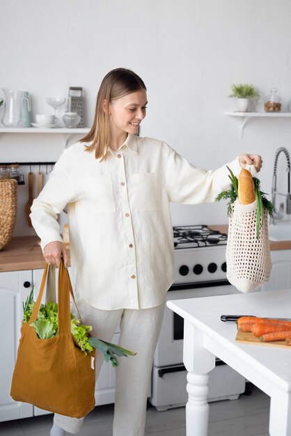 Vista frontal de la mujer con bolsas de la compra.