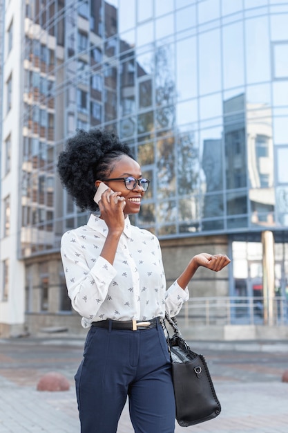 Vista frontal mujer con bolso hablando por teléfono