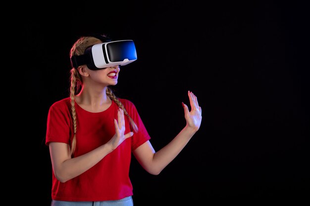 Vista frontal de una mujer bonita jugando vr en juegos de fantasía de ultrasonido oscuro visual