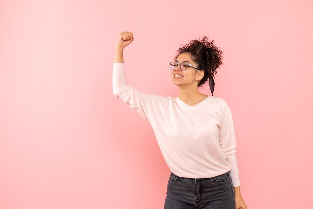 Vista frontal de la mujer bonita regocijándose en rosa