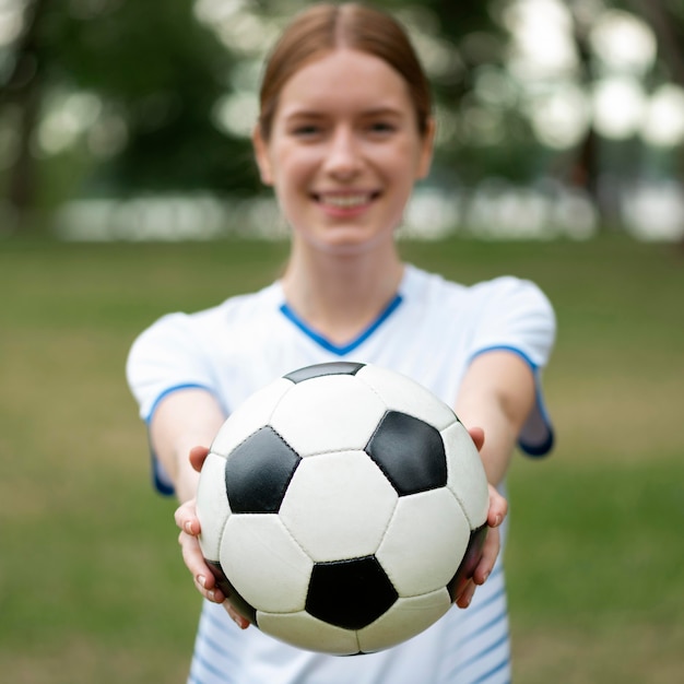 Vista frontal, mujer borrosa, tenencia, pelota