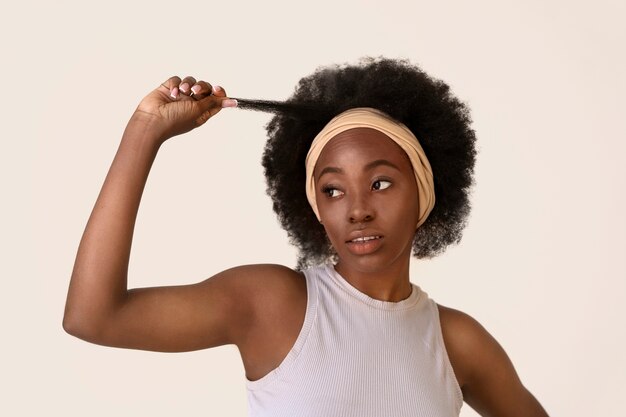 Vista frontal mujer con cabello afro posando