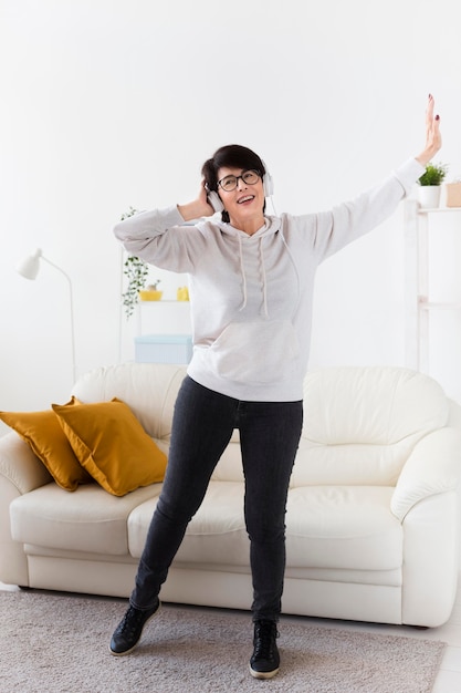 Vista frontal de la mujer en casa con auriculares