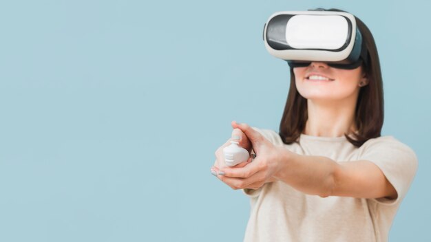 Vista frontal de la mujer con casco de realidad virtual y divertirse