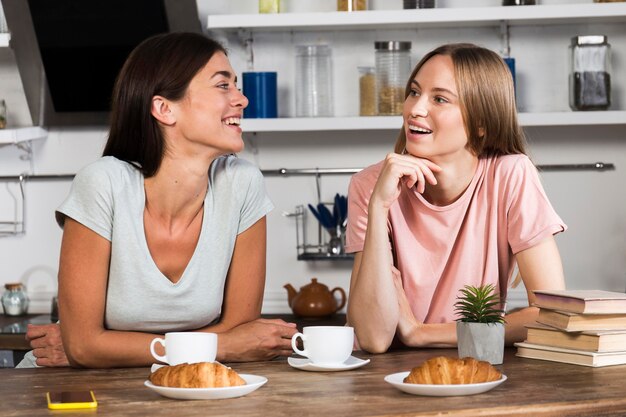 Vista frontal de la mujer charlando con café y croissants