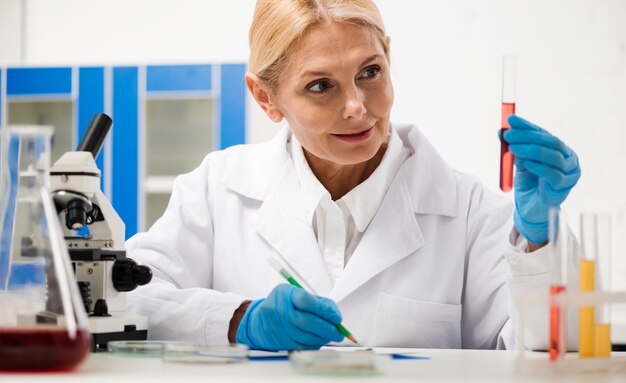 Vista frontal de la mujer científica que trabaja con sustancia de laboratorio