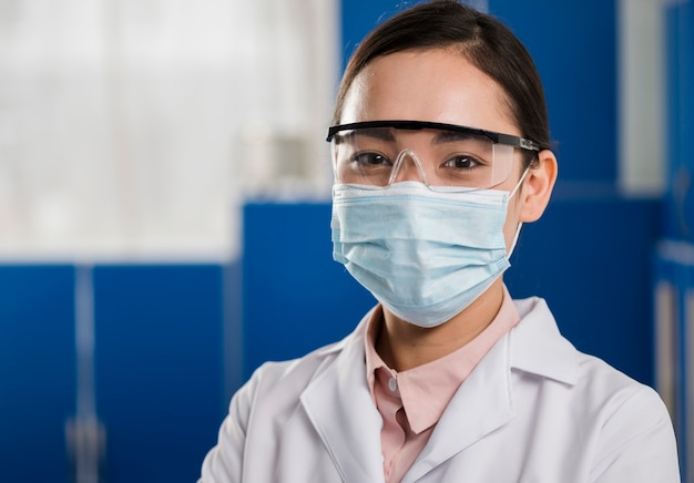 Foto gratuita vista frontal de la mujer científico con máscara médica