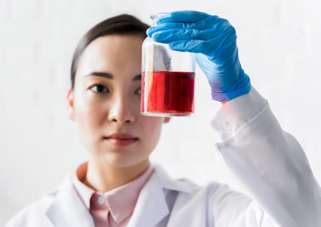 Vista frontal de la mujer científico sosteniendo sustancia de laboratorio