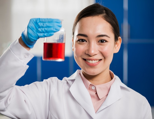 Vista frontal de la mujer científico con sustancia de laboratorio