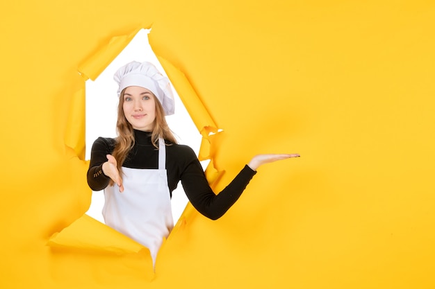 Vista frontal mujer cocinera en amarillo sol cocina comida de cocina de papel de color fotográfico