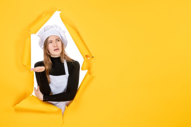 Vista frontal mujer cocinera en papel de color amarillo emoción comida trabajo foto cocina