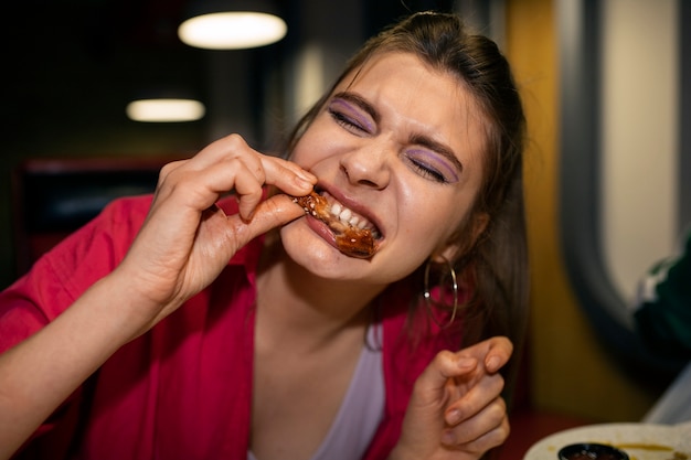 Foto gratuita vista frontal mujer comiendo alitas de pollo