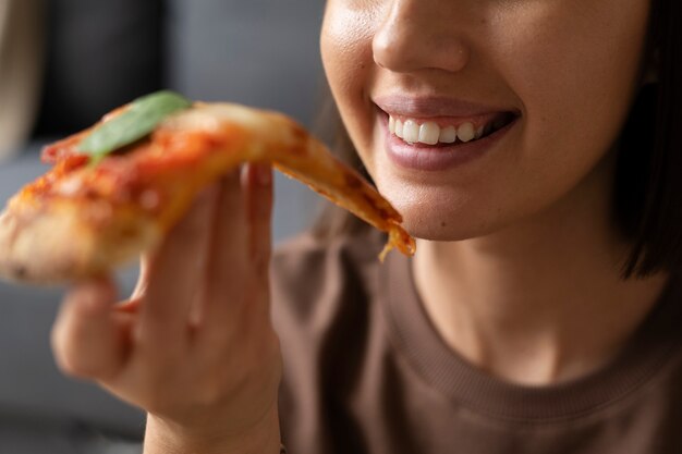 Vista frontal mujer comiendo deliciosa pizza