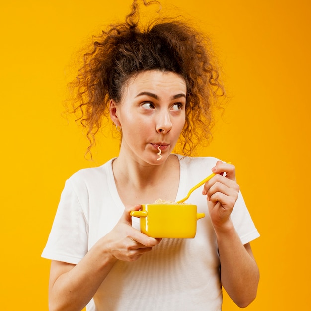 Vista frontal de la mujer comiendo fideos