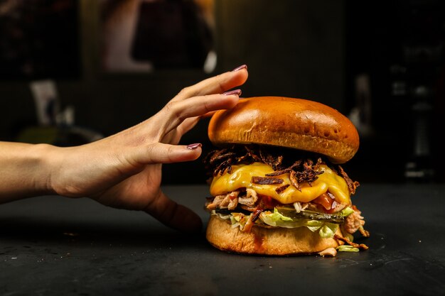 Vista frontal mujer comiendo hamburguesa de carne