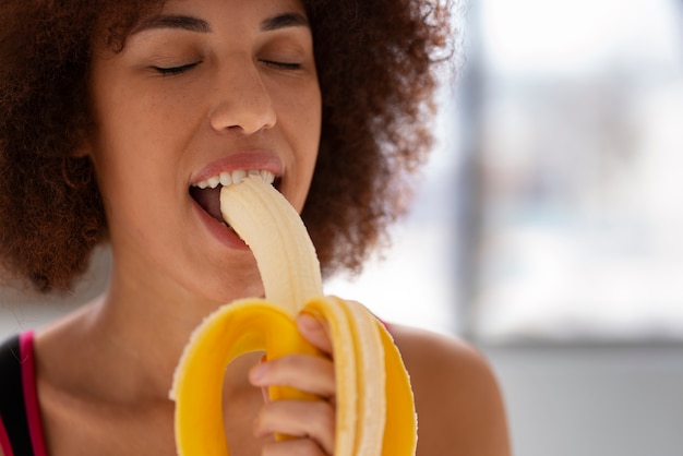 Foto gratuita vista frontal mujer comiendo plátano