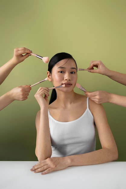 Foto gratuita vista frontal mujer coreana con pinceles de maquillaje
