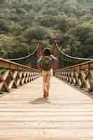 Foto gratuita vista frontal mujer cruzando el puente