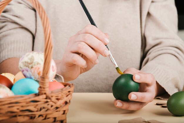 Vista frontal de la mujer decorando huevos de pascua