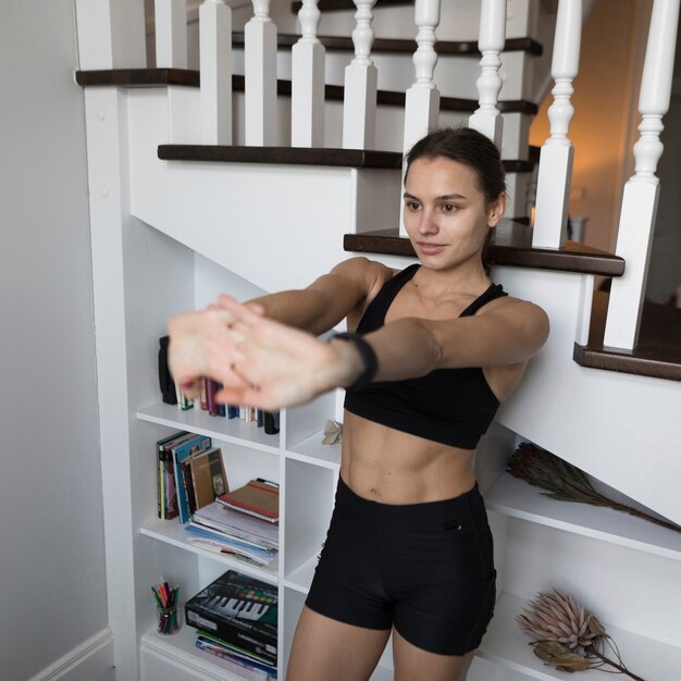 Vista frontal de mujer deportiva estirando los brazos