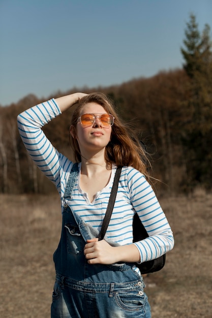Vista frontal de la mujer despreocupada con gafas de sol al aire libre