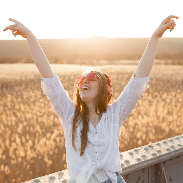 Vista frontal de la mujer despreocupada con gafas de sol en la naturaleza