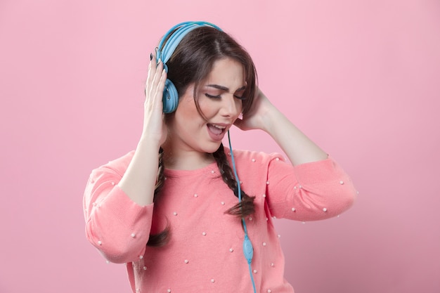 Vista frontal de la mujer disfruta escuchando música con auriculares