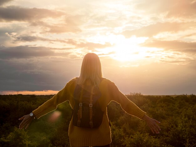 Vista frontal mujer disfrutando del atardecer