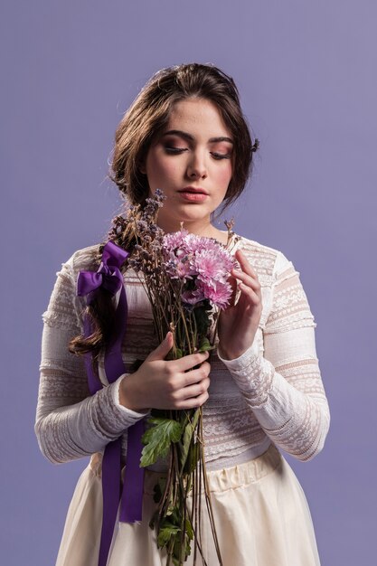 Foto gratuita vista frontal mujer disfrutando de un ramo de flores