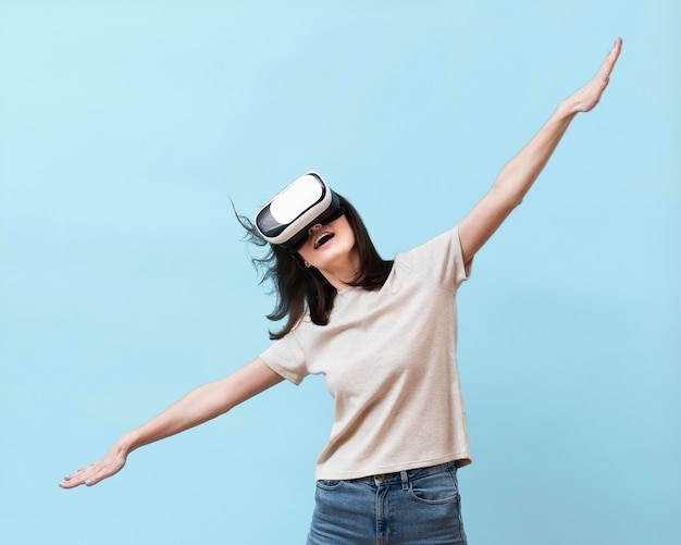 Vista frontal de la mujer divirtiéndose con casco de realidad virtual