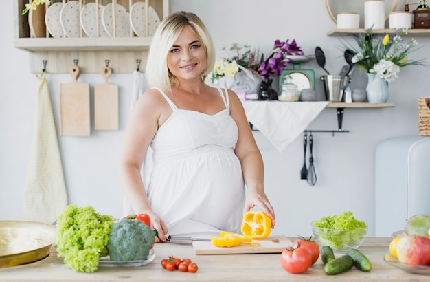 Vista frontal mujer embarazada en la cocina