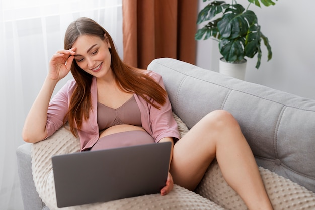 Foto gratuita vista frontal mujer embarazada con laptop