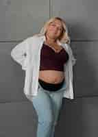 Foto gratuita vista frontal mujer embarazada posando en estudio