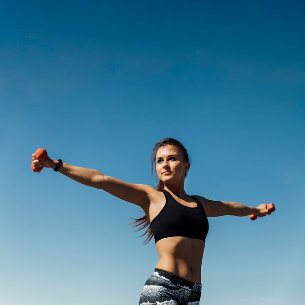 Vista frontal de la mujer entrenando con pesas