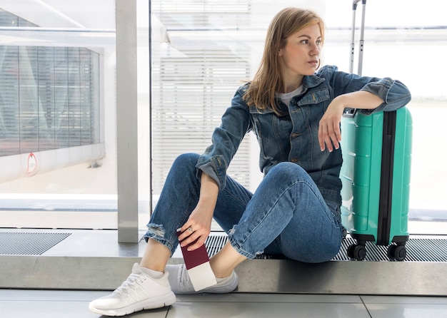 Vista frontal de la mujer esperando su vuelo