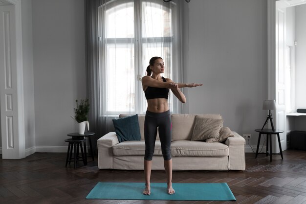 Vista frontal de la mujer estirando y preparándose para hacer ejercicio