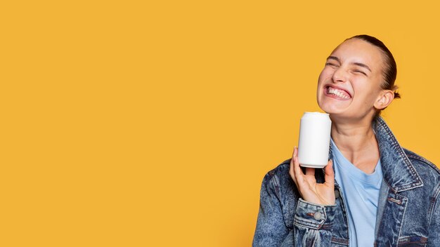 Vista frontal de la mujer extática con lata de refresco y espacio de copia