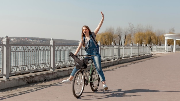 Vista frontal de la mujer feliz andar en bicicleta