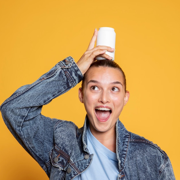 Vista frontal de la mujer feliz con lata de refresco en la cabeza