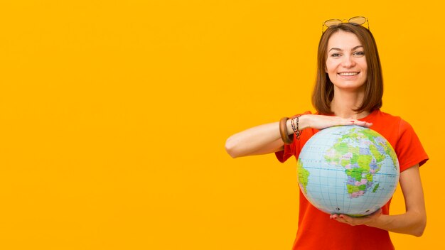 Vista frontal de la mujer feliz que sostiene el globo con espacio de copia