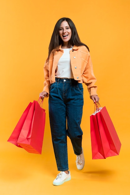 Foto gratuita vista frontal de la mujer feliz sosteniendo bolsas de la compra.