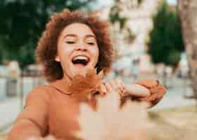 Foto gratuita vista frontal mujer feliz sosteniendo una hoja seca