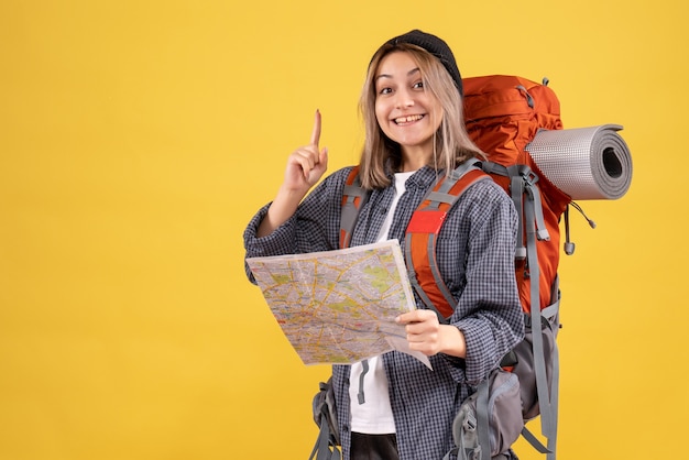 Vista frontal de la mujer feliz viajero con mochila con mapa sorprendente con una idea