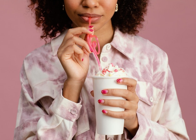 Vista frontal de la mujer con frappe y paja